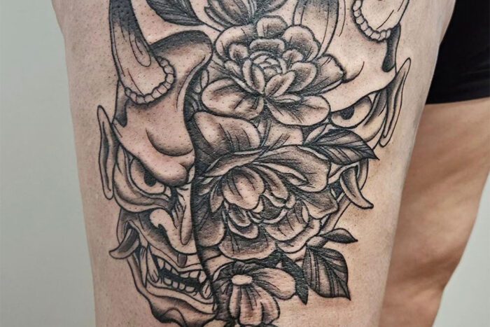 Split Oni mask and flowers tattoo